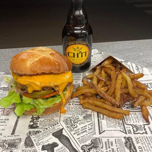 Cheeseburger au cheddar fondu, salade et cornichons, avec frites maison