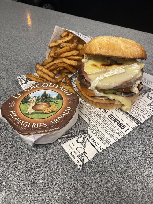 Cornet de frites maison et burger au fromage sur papier journal